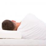 Man sleeping on his side on a pillow and mattress