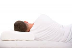 Man sleeping on his side on a pillow and mattress